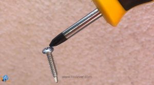 a magnetic screwdriver tip picking a screw